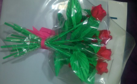 Arreglo que consta de 12 rosas envueltas en plástico y con un pequeño moño.